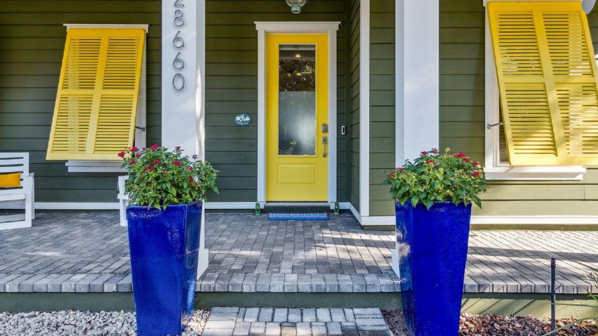Check Out the Bold Yellow Door Framed by Vibrant Blue Planters