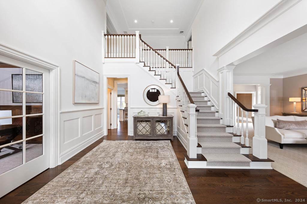 Grand Foyer with Elegant Staircase and Detailed Millwork