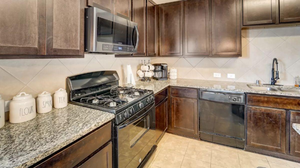 Efficient Kitchen Layout with Dark Wood Cabinets and Granite Surfaces