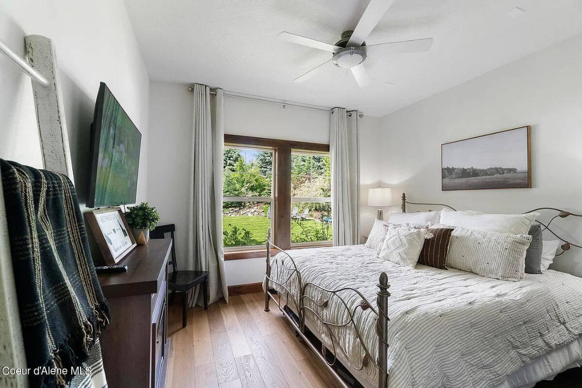 Check Out the Inviting Bedroom with Iron Bedframe and Garden Views