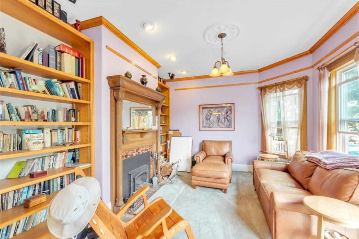 Cozy Reading Nook with Lavender Walls and Built-In Bookshelves