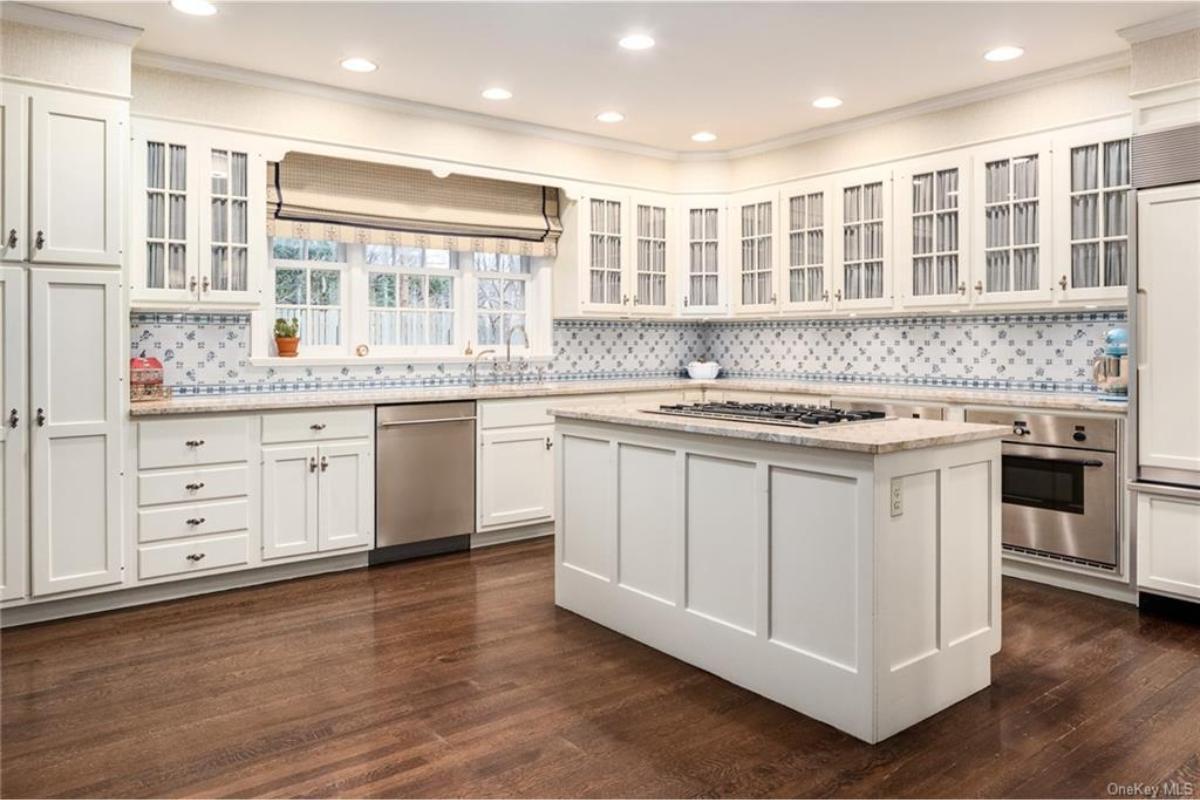 Classic Kitchen with Tiled Backsplash and Glass-Front Cabinets