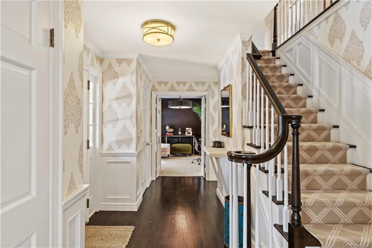 Step into This Elegant Foyer with Chic Wallpaper and a Grand Staircase