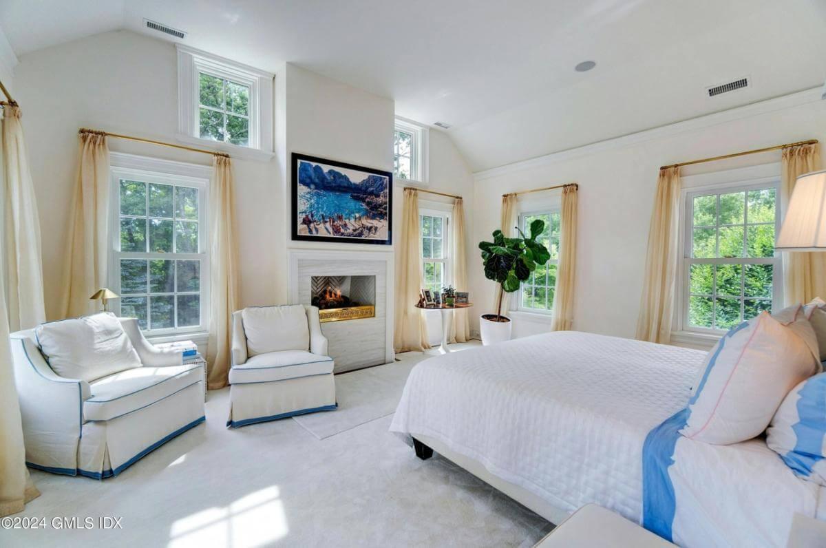 Unwind in This Serene Bedroom Highlighted by a Cozy Fireplace