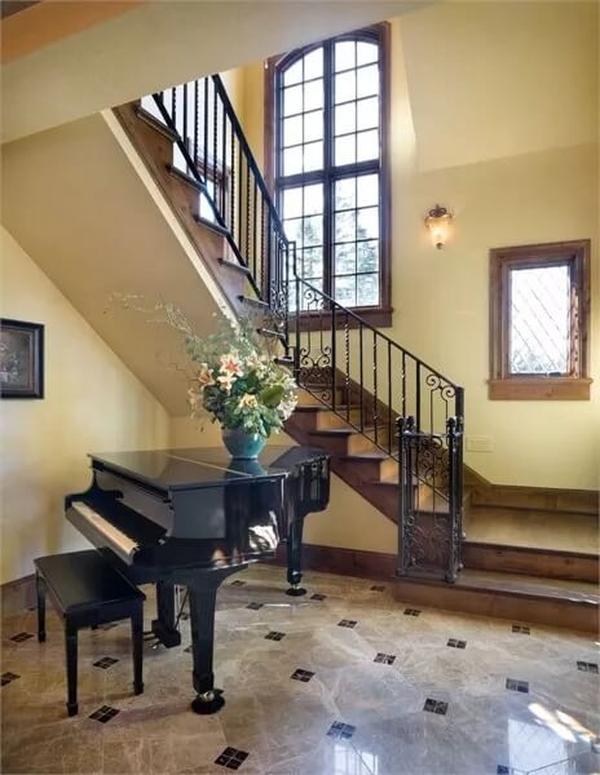 Grand Staircase with Musical Flair: Piano Nestled Underneath