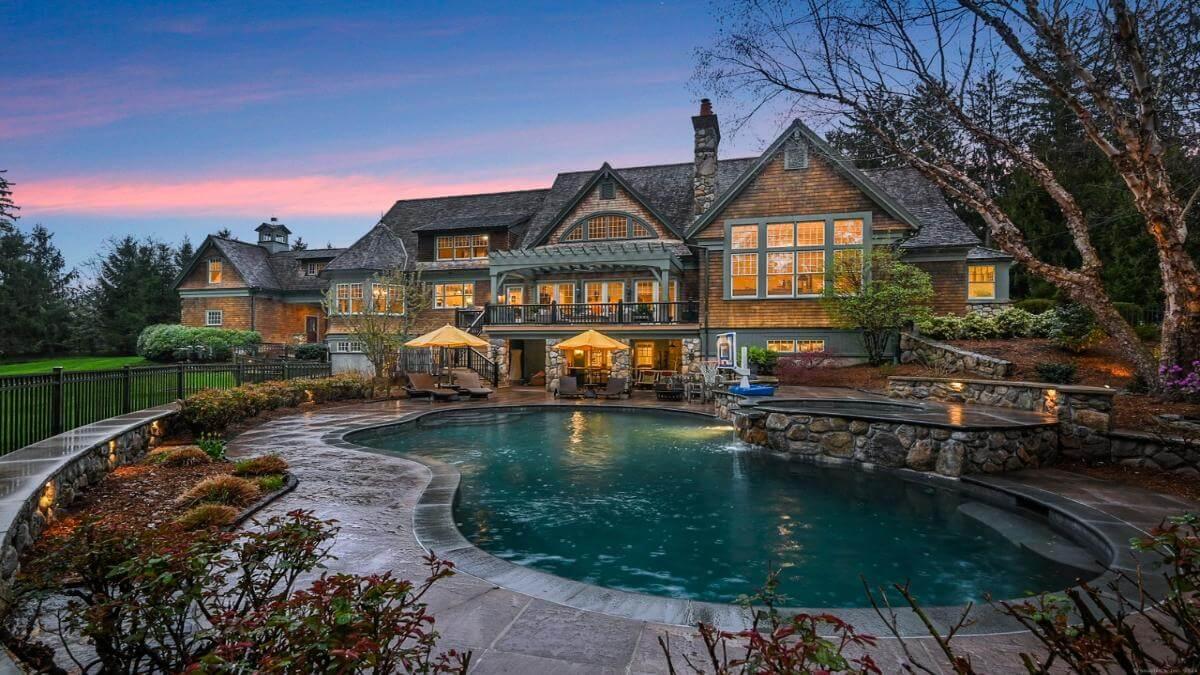 Craftsman Exterior with Inviting Stone Patio and Poolside Ambiance