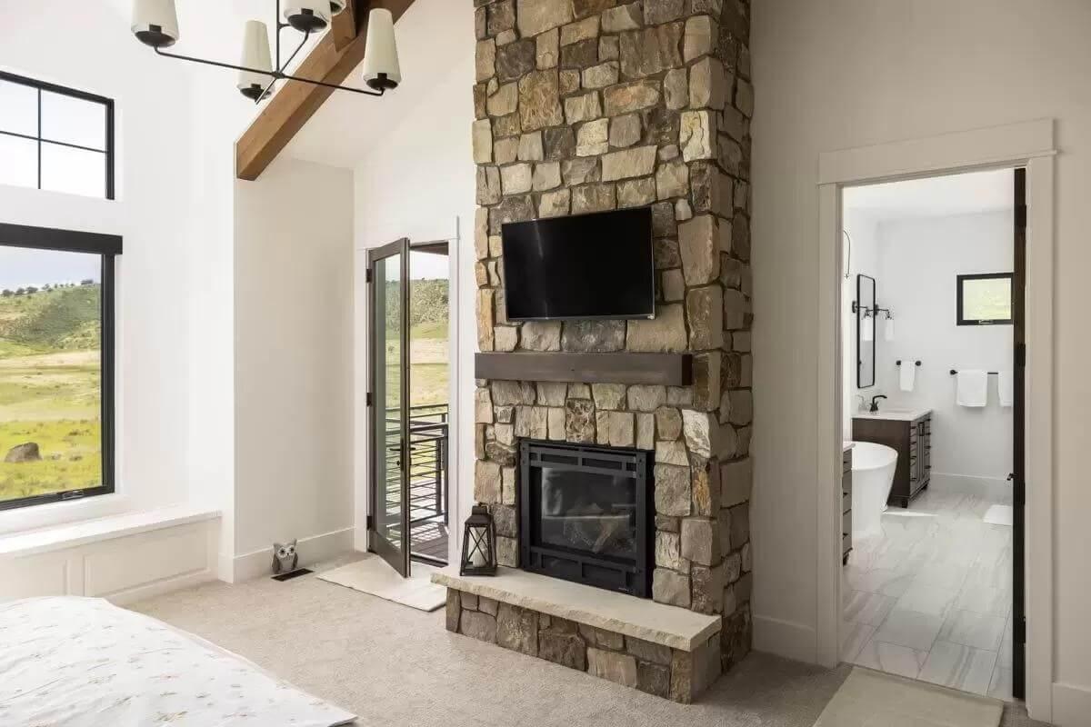 Bedroom with Stone Fireplace Leads to an Inviting Bath