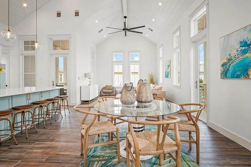 Open-Concept Dining Area with a Striking Glass Table and High Ceilings