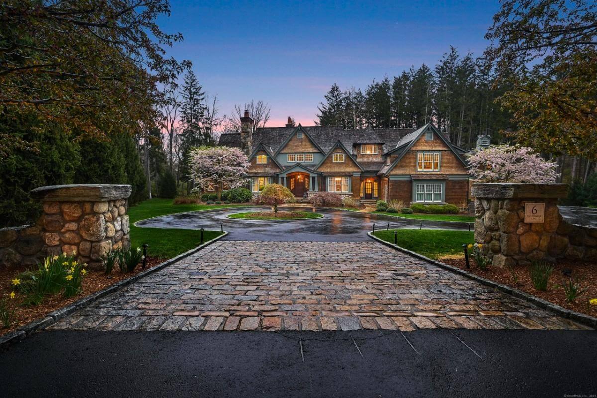 Inviting Craftsman Entrance with Cobblestone Driveway at Dusk
