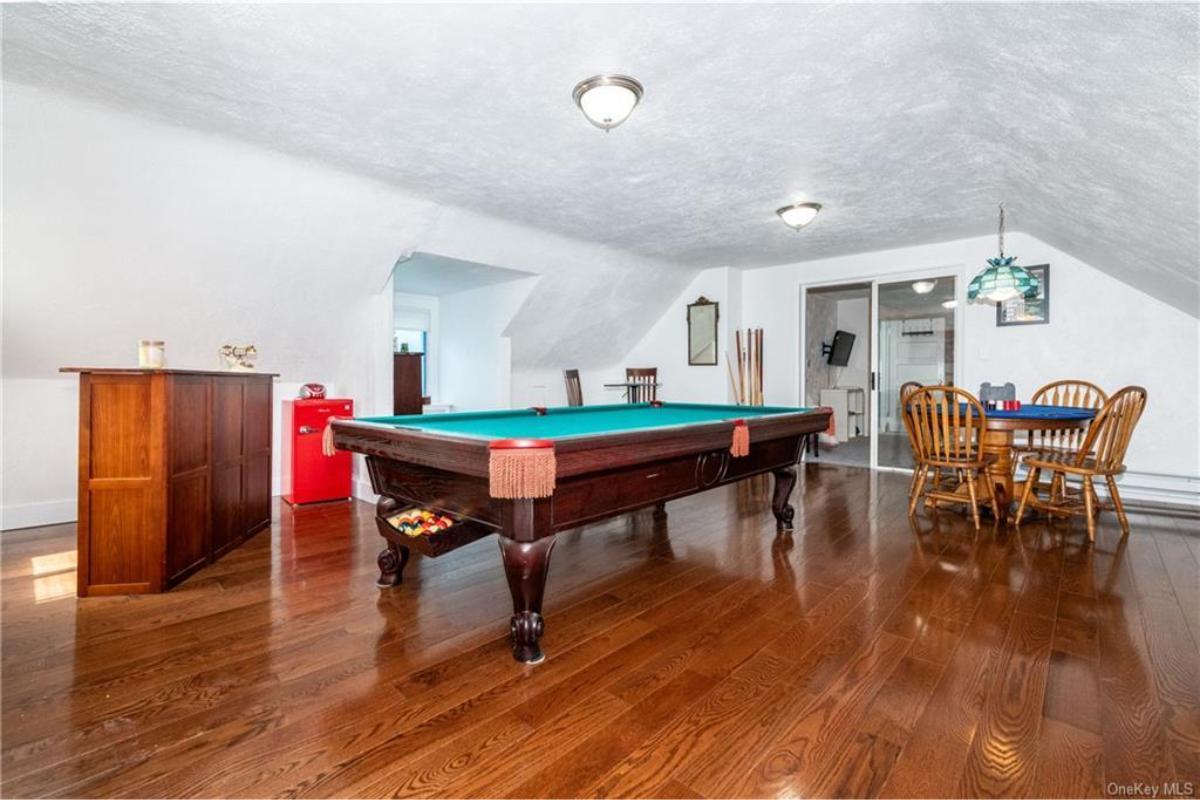 Dive into This Game Room with Rich Hardwood Floors and a Pool Table