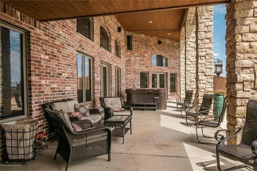 Relax on This Expansive Brick Patio with Rustic Stone Columns