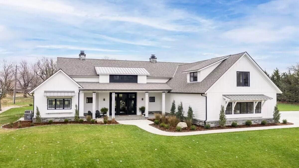 Farmhouse with Distinctive Awning Accents and Spacious Front Lawn
