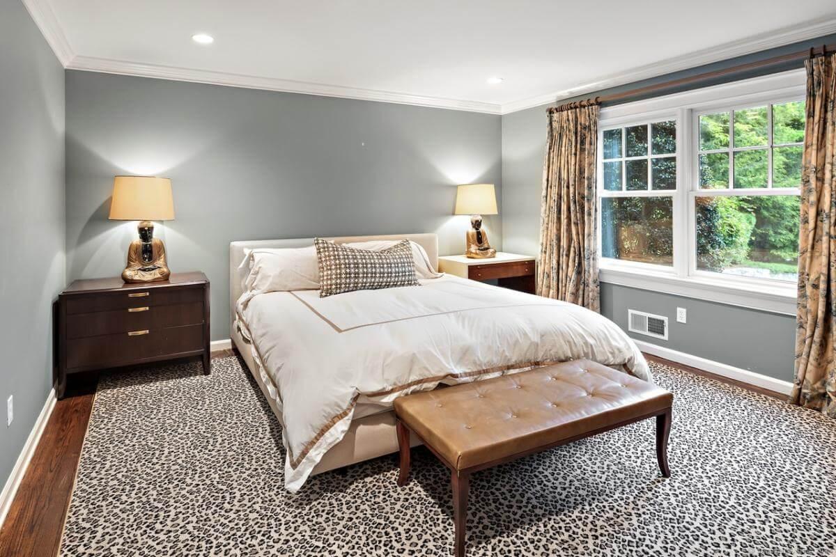 Cozy Bedroom with Unique Leopard Print Carpet and Tranquil Green Walls