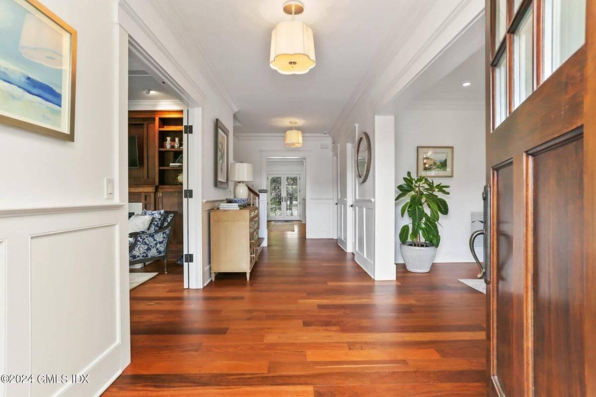 Step Into This Craftsman Foyer with Rich Wood Floors and Elegant Paneling