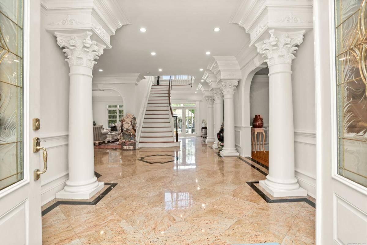 Step Into This Grand Entrance with Majestic Columns and Gleaming Floors