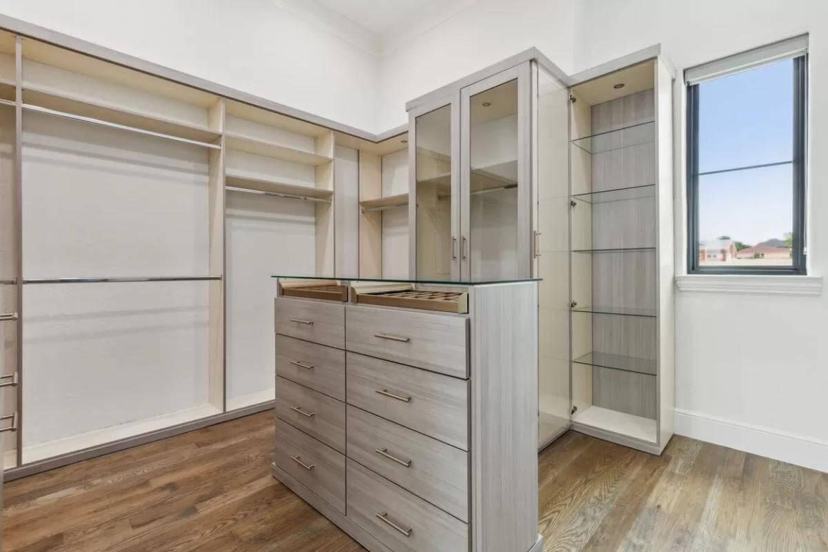Sleek Walk-In Closet with Glass-Top Island and Plenty of Storage