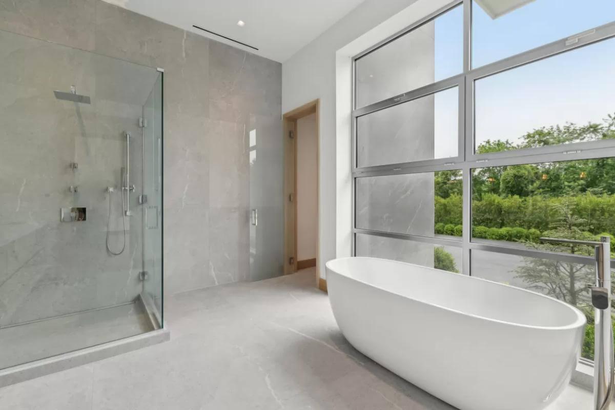 Freestanding Tub with Floor-to-Ceiling Windows in a Sleek Bathroom