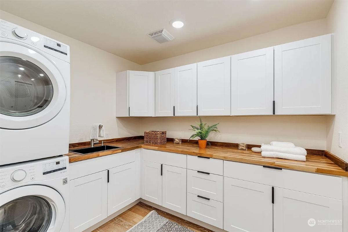 Admire the Warm Wood Countertops in This Bright Laundry Room