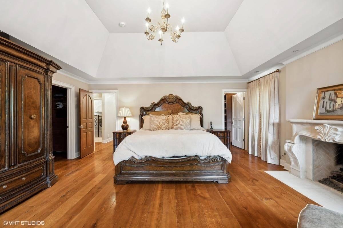 This Primary Bedroom Has an Ornate Wooden Bed as the Focal Point