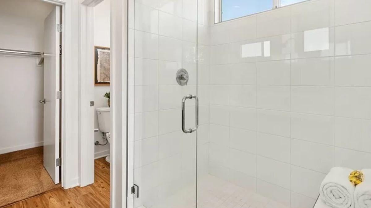 Notice the Crisp White Shower Tiles and Sleek Glass Door