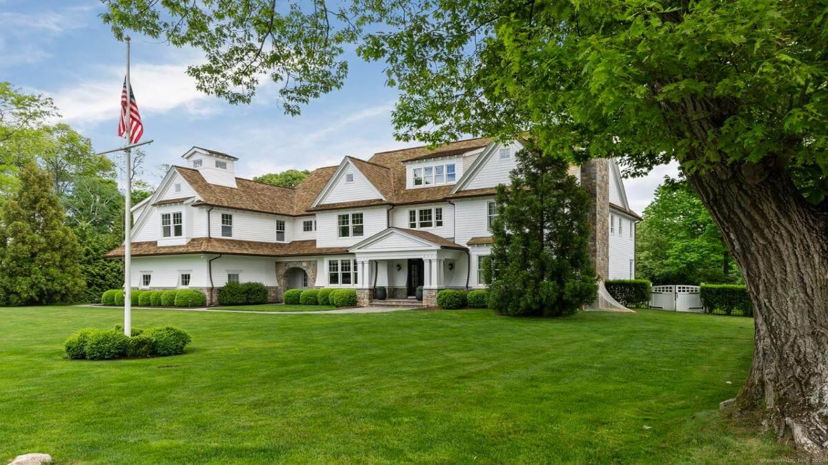 Classic Colonial Charm with a Mansard Roof and Stone Accents