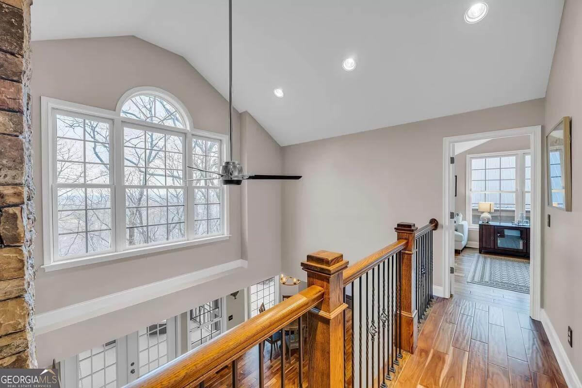 Admire the Lofty Landing with Arched Windows and Wood Accents