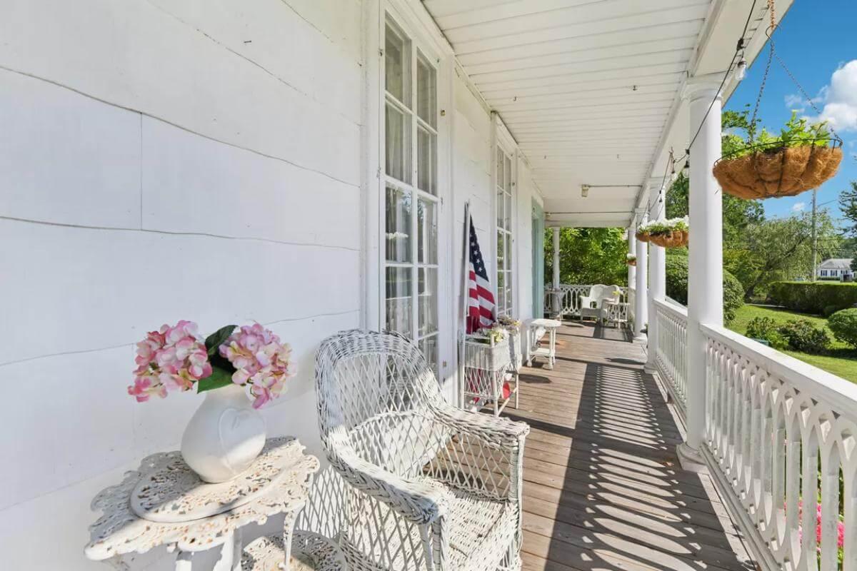 Classic Wraparound Porch with Wicker Charm and Hanging Baskets