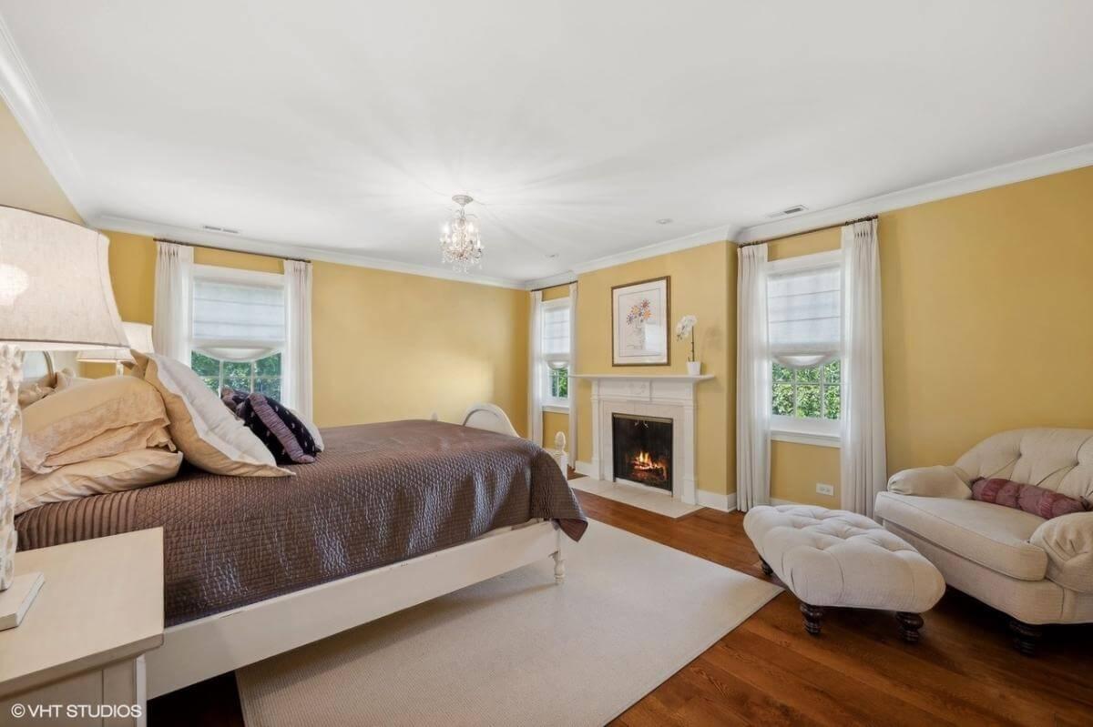 Check Out the Warm Tones and Cozy Fireplace in This Bedroom Retreat