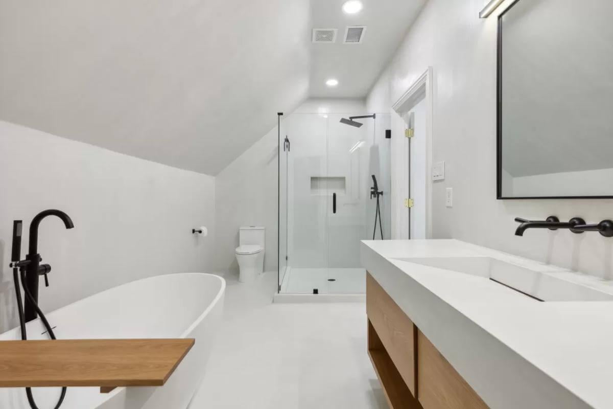 Sleek Bathroom with Freestanding Tub and Angled Ceiling Charm