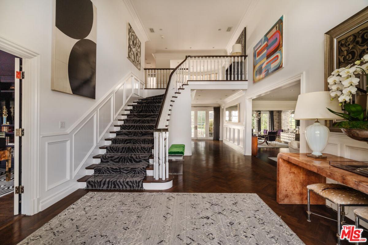 Grand Foyer Featuring a Statement Staircase with Zebra-Patterned Runner
