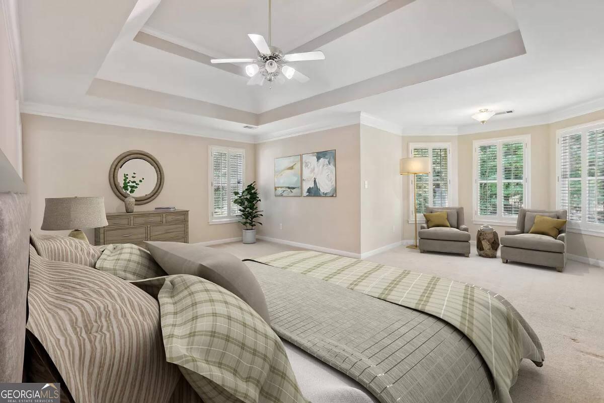 Inviting Master Bedroom with a Cozy Sitting Area and Tray Ceiling