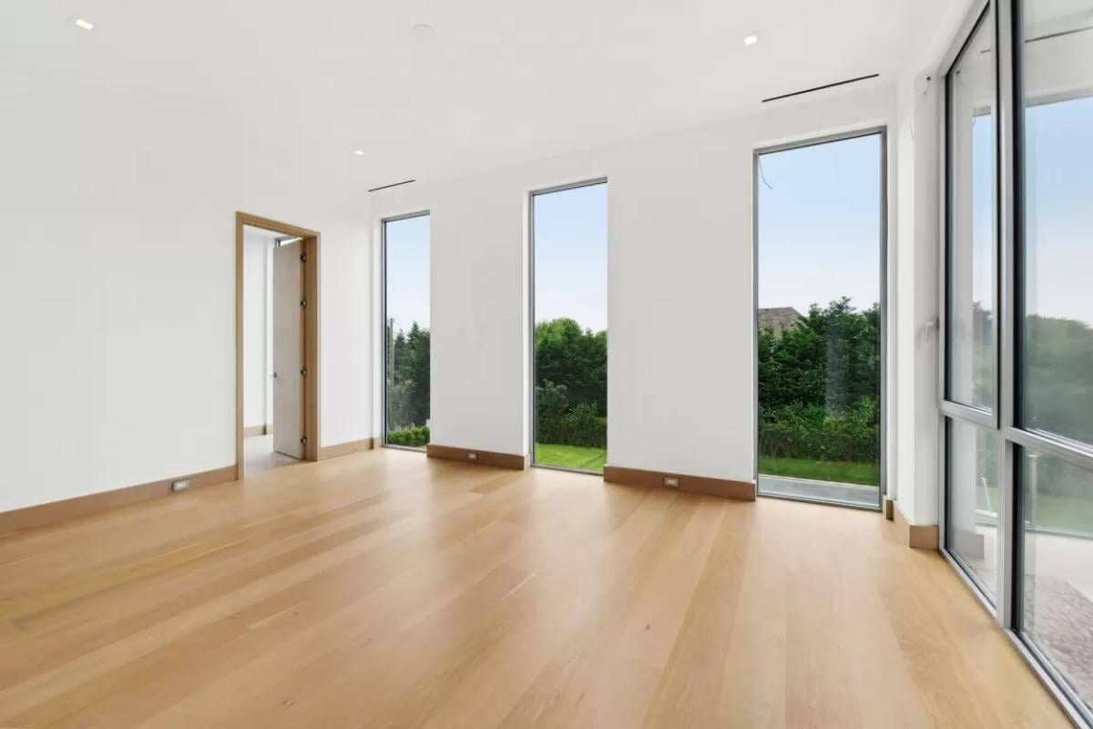 Expansive Windows Framing Verdant Views in this Minimalist Space