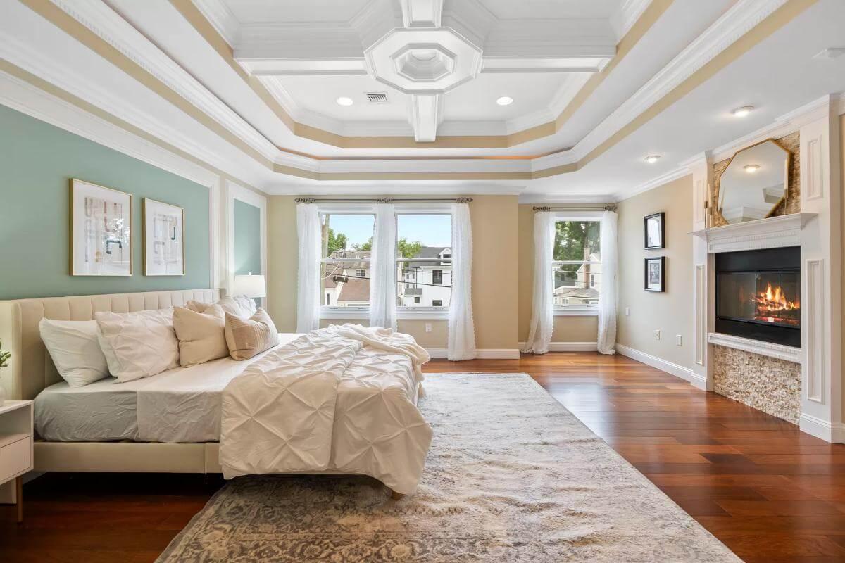 Admire the Tray Ceiling and Fireplace in This Spacious Bedroom