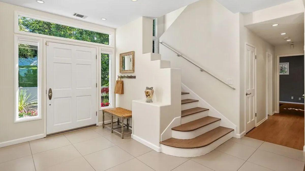 Welcome to This Entryway with Bright Windows and a Curved Staircase