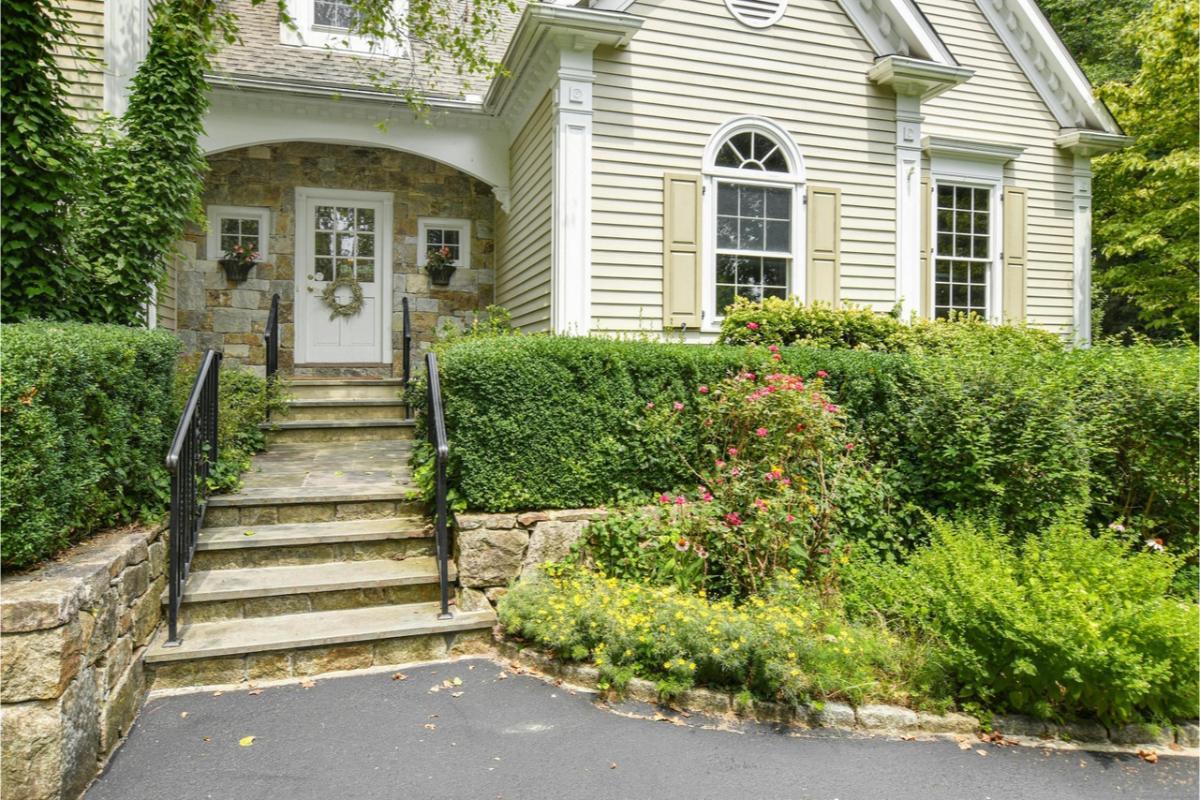 Charming Entrance Featuring Classic Stonework and Lush Greenery