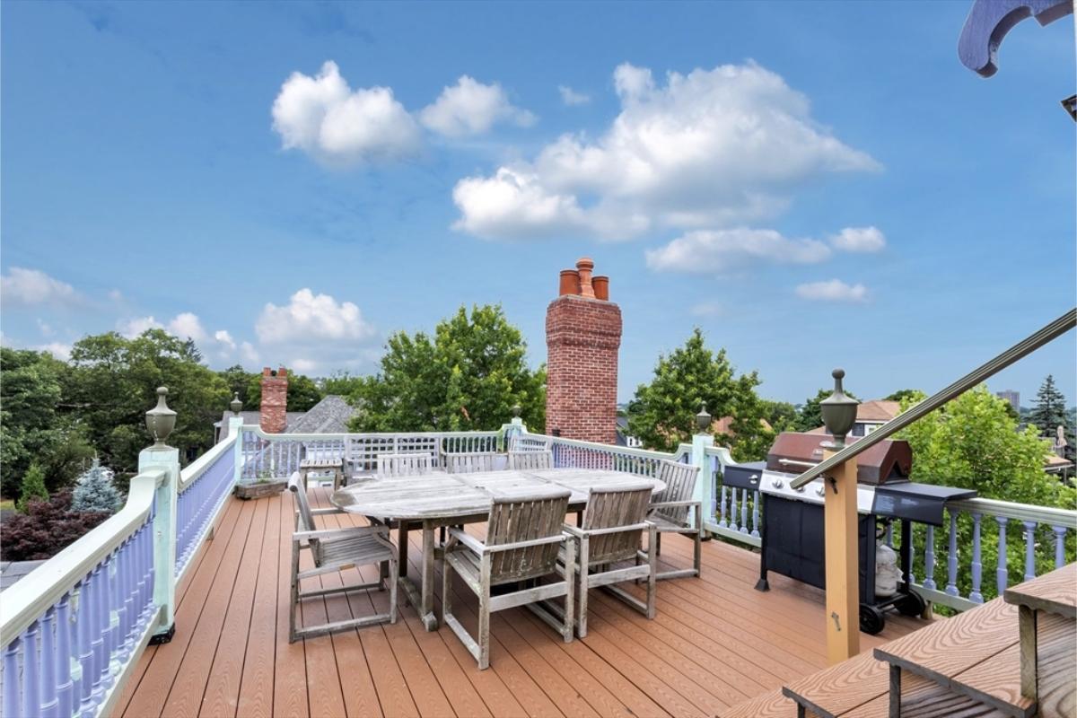 Relaxing Rooftop Deck with Scenic Views and Brick Chimney Accents