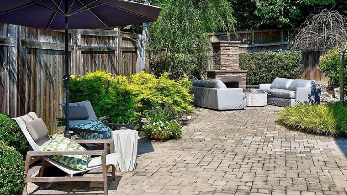 Relax in This Inviting Patio with Brick Fireplace and Plush Seating
