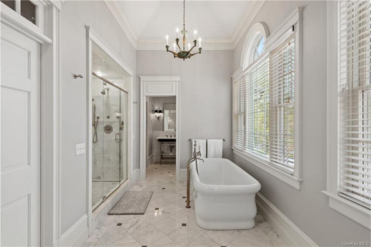 Relax in This Elegant Bathroom with a Clawfoot Tub and Grand Chandelier