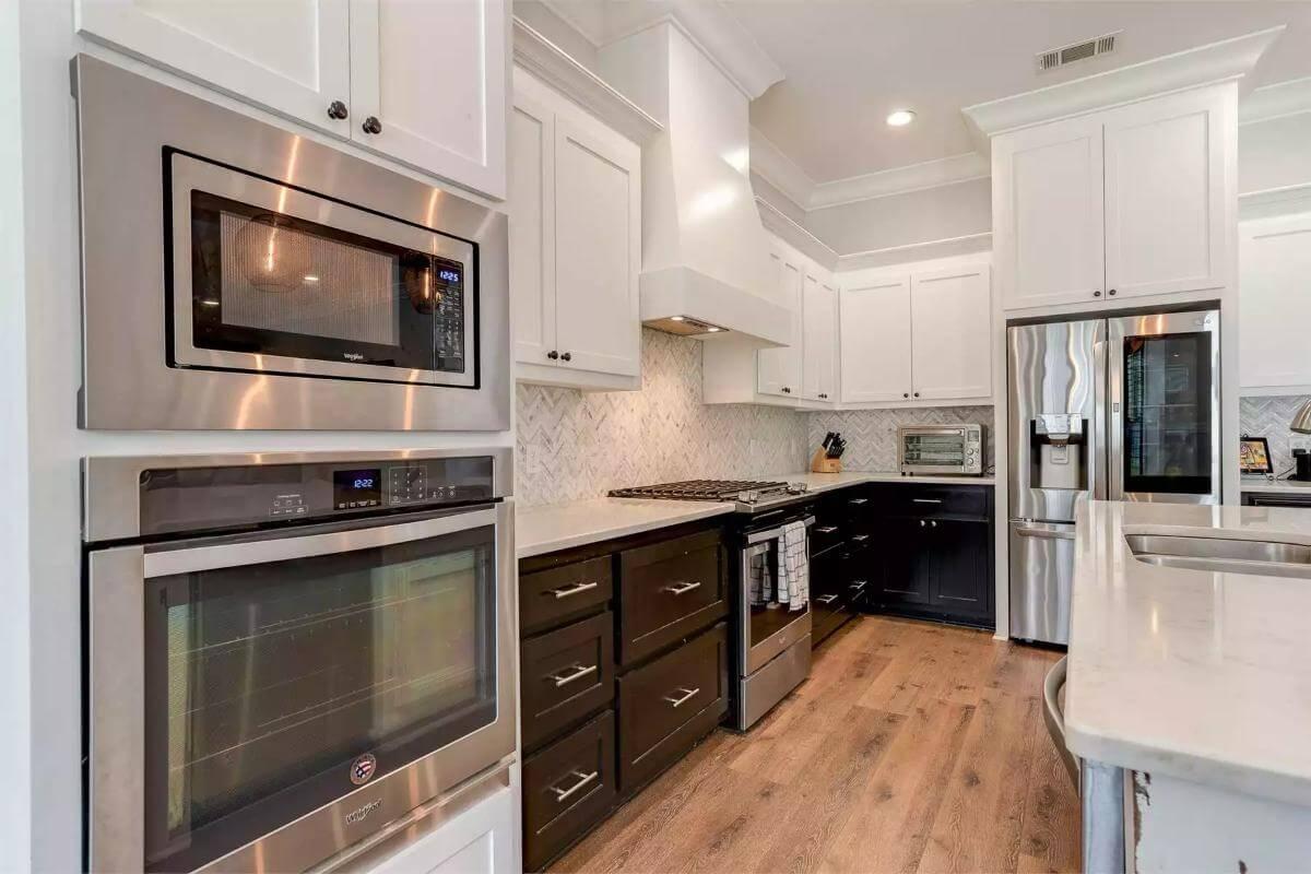 Dual-Toned Kitchen with Herringbone Backsplash as a Design Highlight