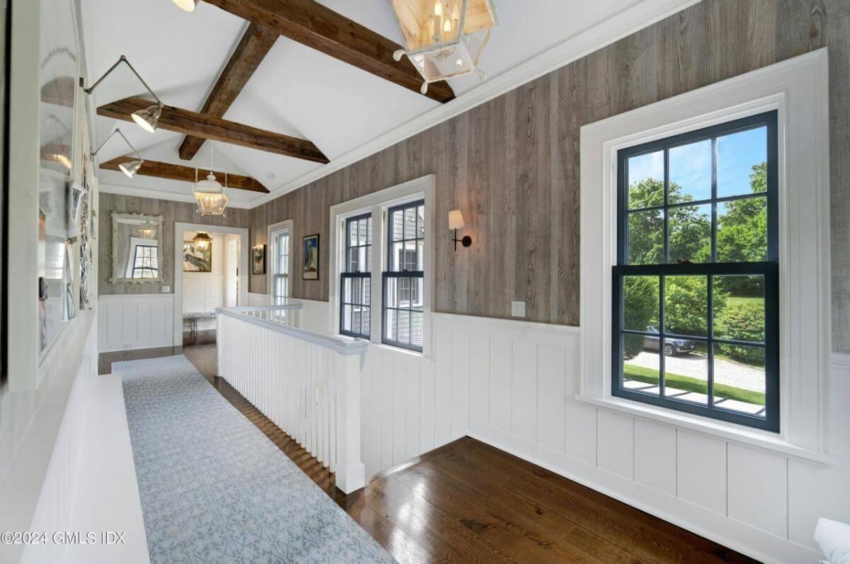Notice the Rustic Beams and Wood Paneling in This Light-Filled Hallway
