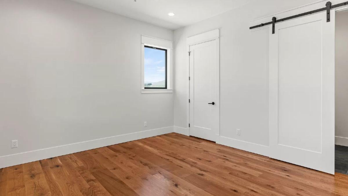 Notice the Sleek Barn Door and Warm Wood Floors in This Room