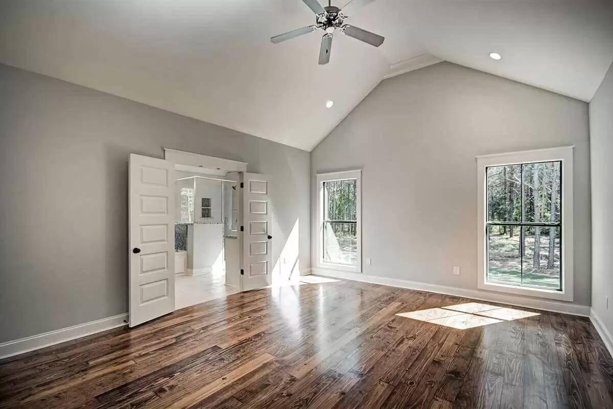 Discover the Vaulted Ceilings and Rich Wooden Floors in This Bedroom