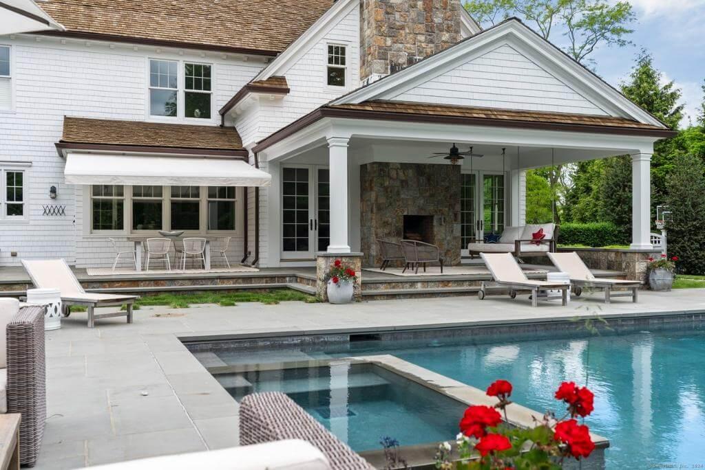 Outdoor Living at Its Best with a Stone Fireplace and Poolside Comfort