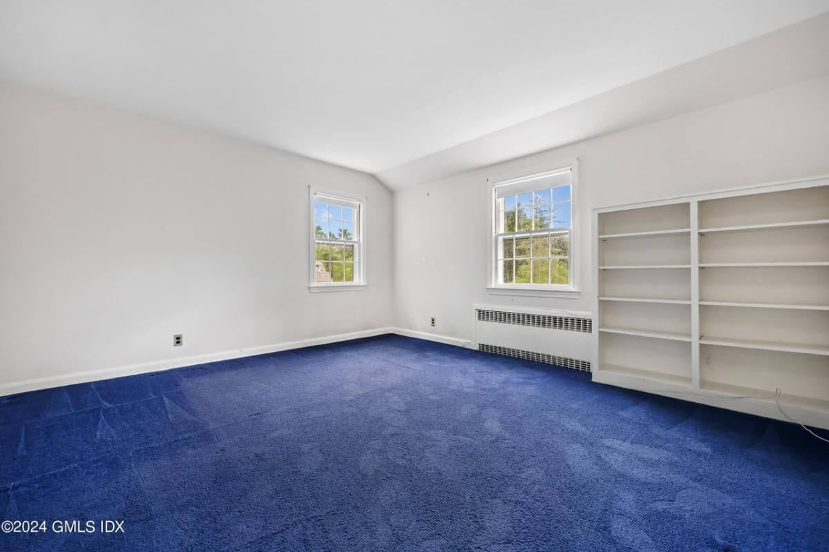 Versatile Room with Built-In Shelving and Bold Carpet
