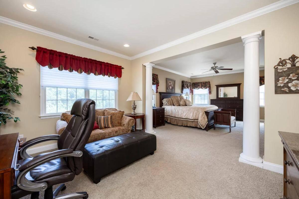 Elegant Master Suite with Cozy Sitting Area Framed by Classic Columns
