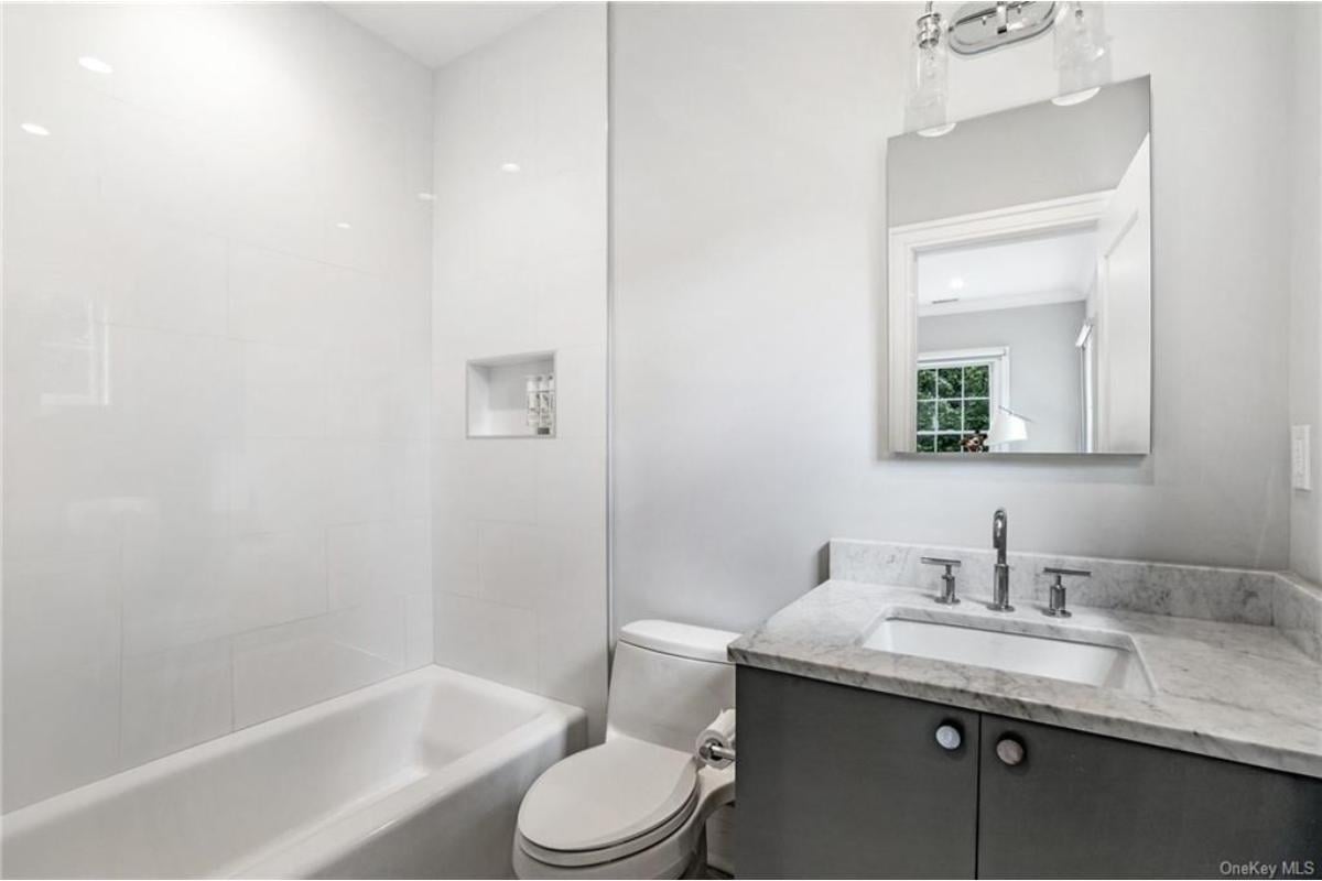 Sleek Bathroom with Marble Accents and Bright Lighting