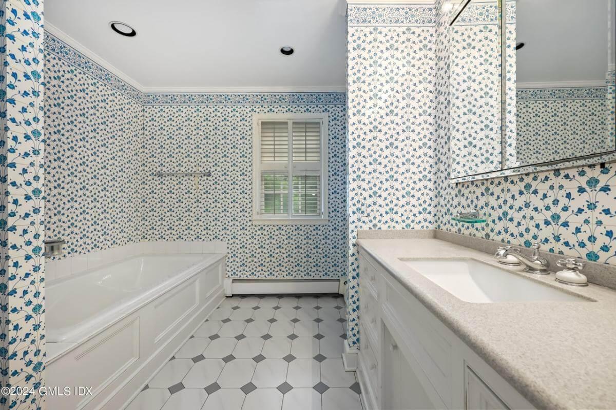 Charming Bathroom with Vintage Floral Wallpaper and a Hex Tile Floor