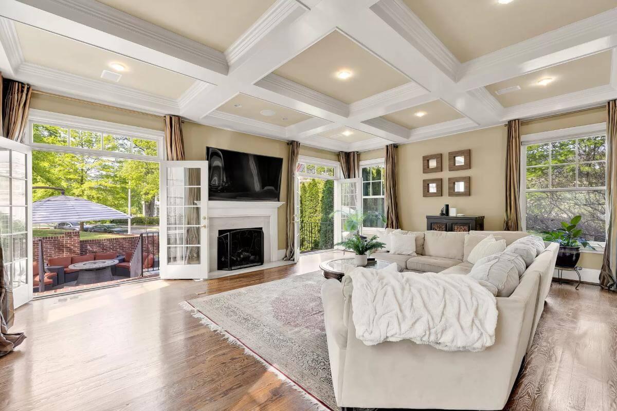 Step into This Bright Living Room with a Coffered Ceiling and Cozy Fireplace