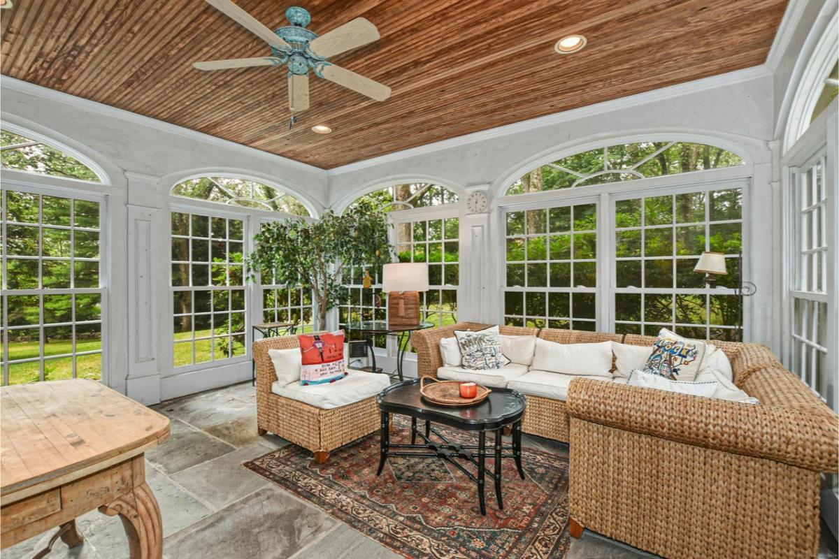 Step into a Charming Sunroom with Wicker Furniture and a Warm Wooden Ceiling