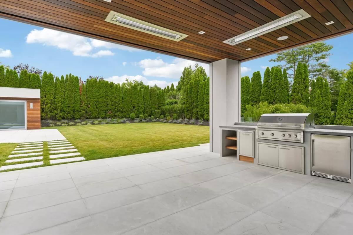 Sleek Backyard Living: Check Out the Built-In Grill Surrounded by Verdant Views